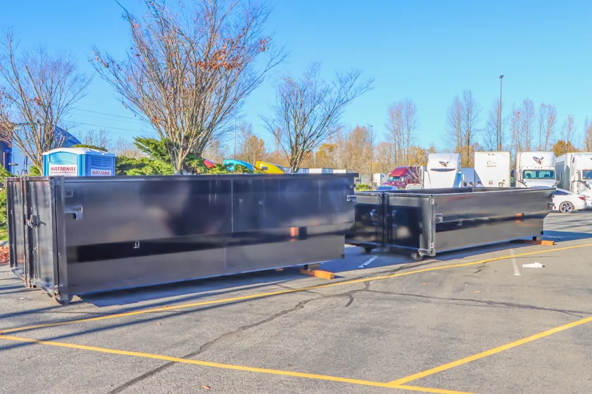 Professional dumpster rental service with roll-off container on residential driveway in Rapho